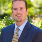 Michael Burns in blue suit with honeycomb tie